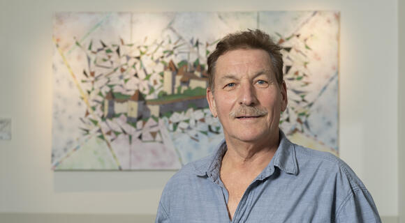 Portrait de Claude Rossier devant une de ses toiles