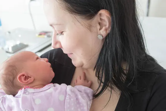 Gros plan sur un échange de regards entre la maman et son bébé. 