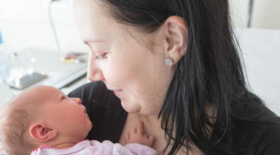 Gros plan sur un échange de regards entre la maman et son bébé. 